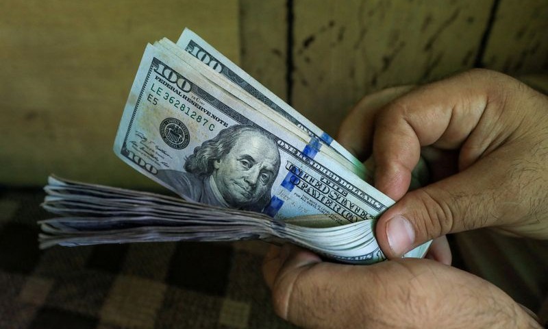 The dollar dropped to a three-week low in choppy trading on Friday,